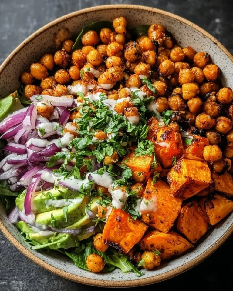 Roasted chickpea and sweet potato bowl garnished with greens and spices