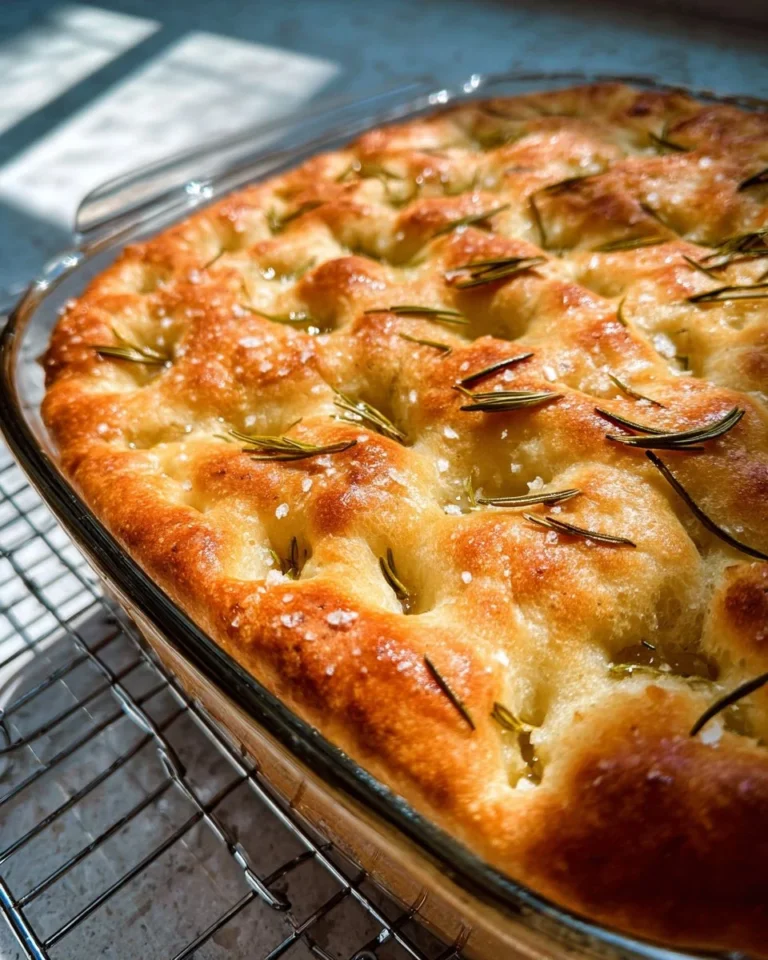 Homemade basic rosemary focaccia bread topped with fresh rosemary.